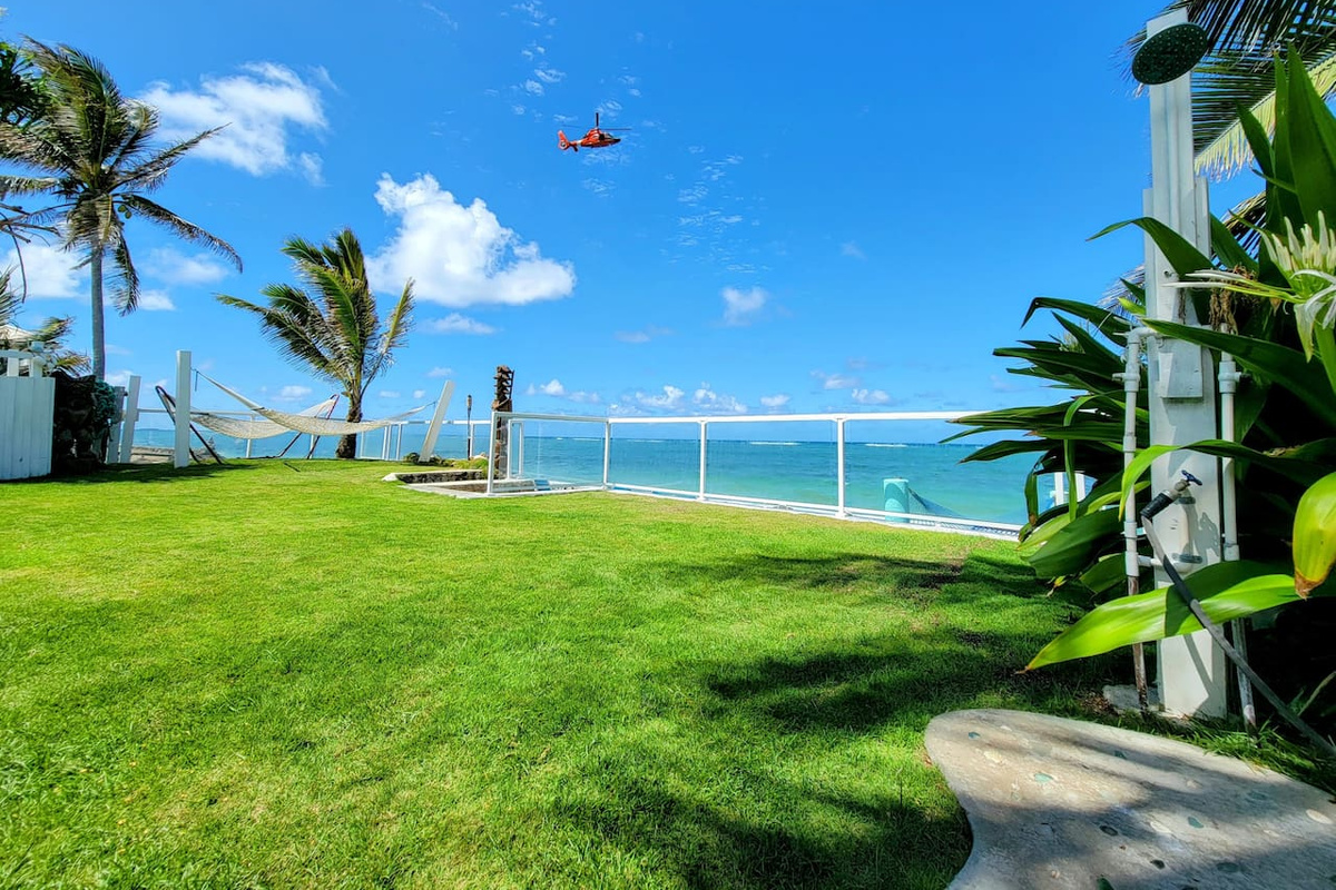 View of Baywatch Hawaii helicopter while sitting in the home's 7-person beachfront jacuzzi, which is the third jacuzzi on the home's beachfront garden