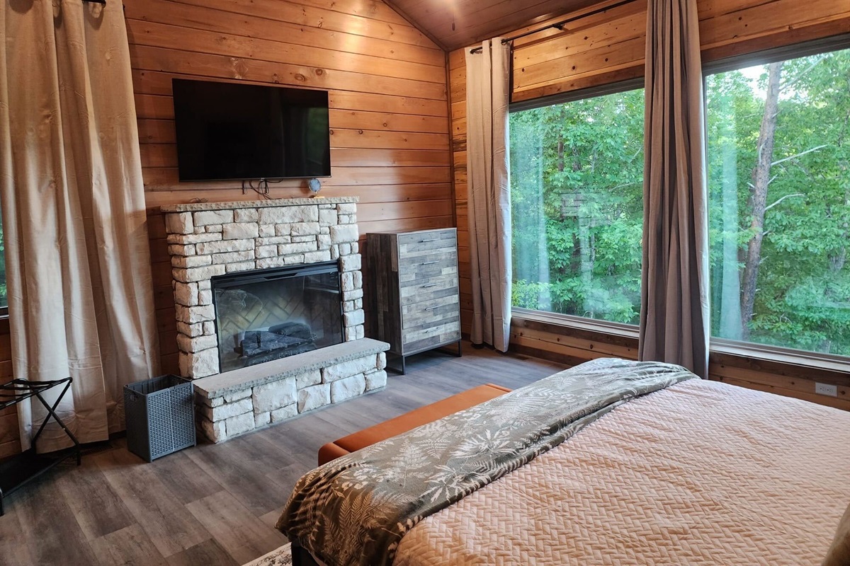 Bedroom with king bed, wood paneling, and cozy decor