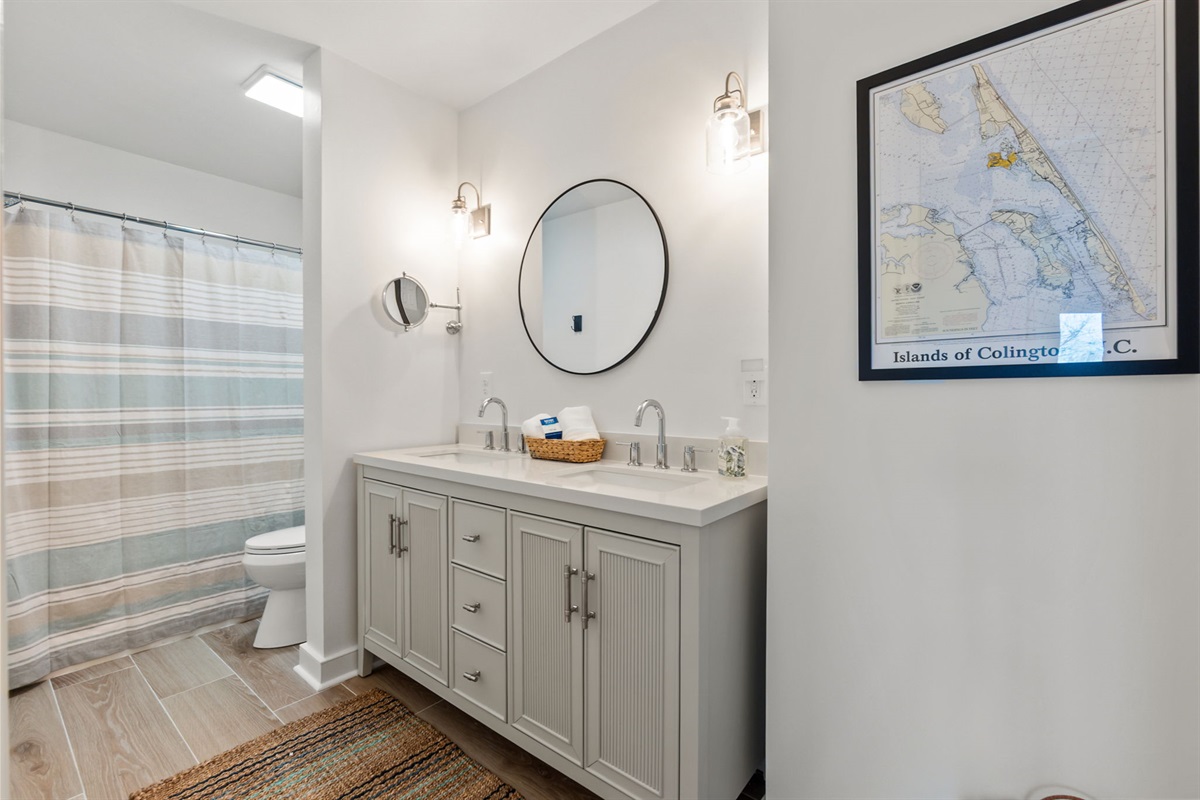 Full Bathroom with double vanity, large mirror, and a shower