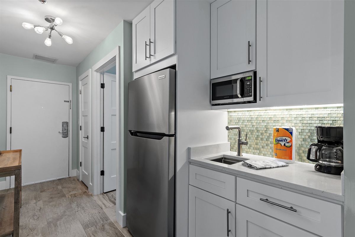 Kitchenette with large refrigerator and freezer, sink, microwave, and coffee bar!