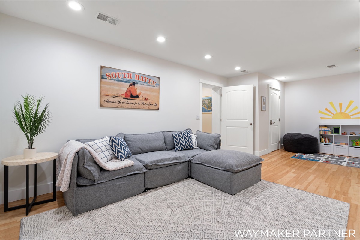 Our comfortable bright living room (3rd shared space) in the basement has a play area for kids and an arcade!
