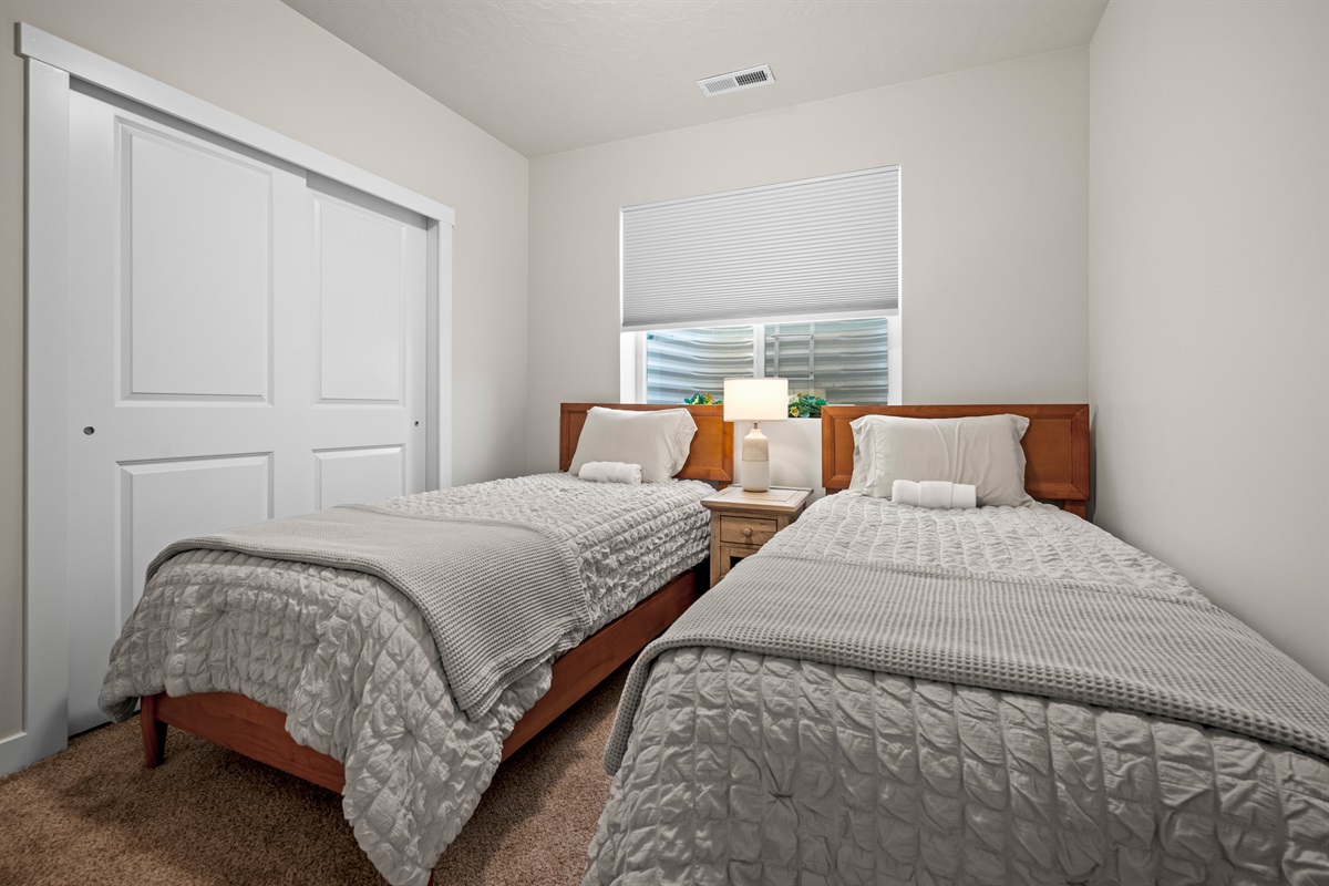 Perfect for kids or extra guests, this bedroom offers twin beds, a roomy double closet, and a sunny window for added warmth.