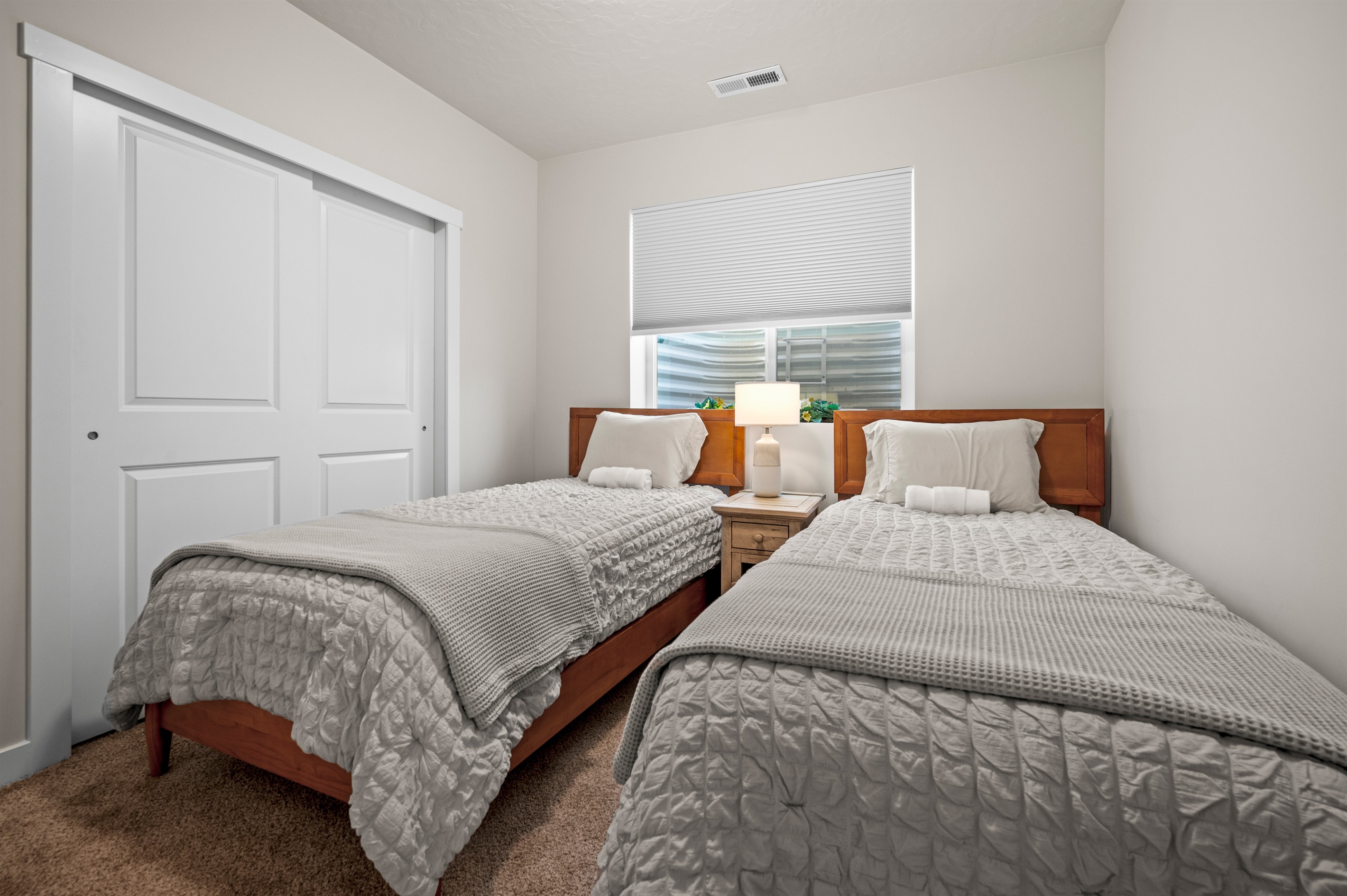 Perfect for kids or extra guests, this bedroom offers twin beds, a roomy double closet, and a sunny window for added warmth.