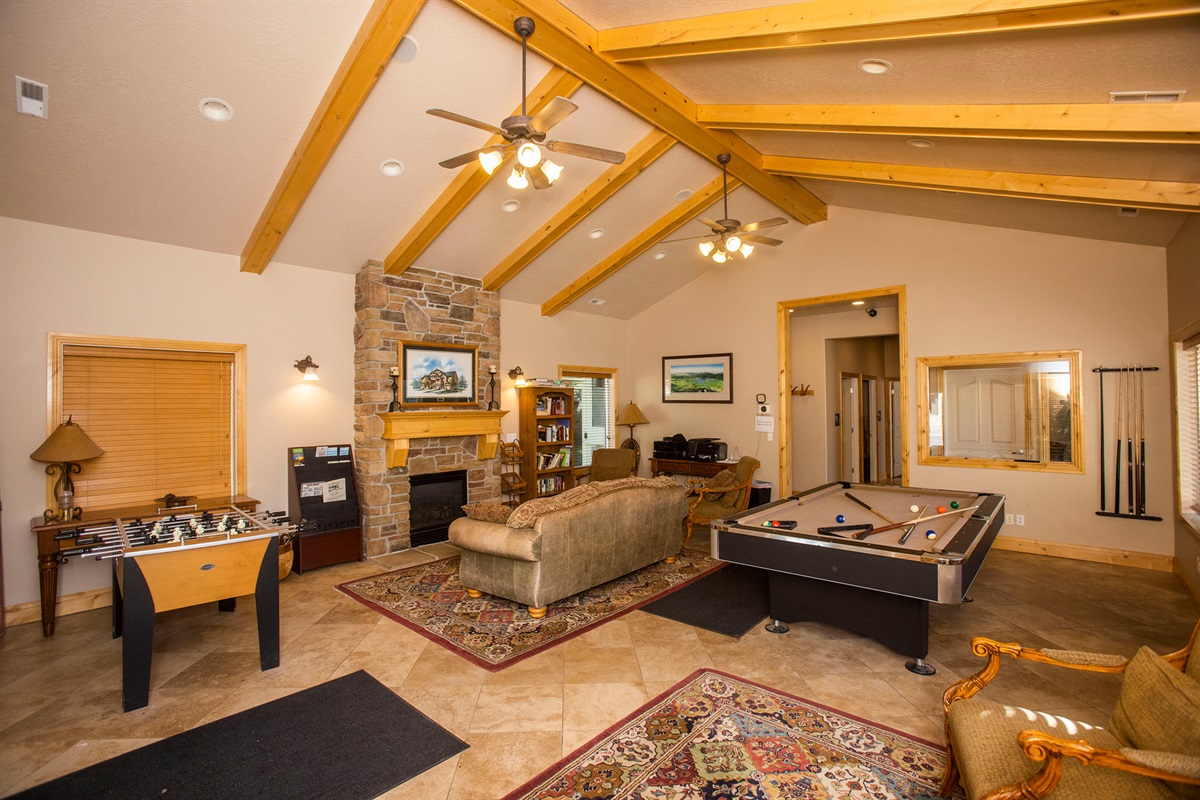 A spacious, lodge-style game room with soaring ceilings, billiards, foosball and lounge seating—perfect for relaxing and entertaining.