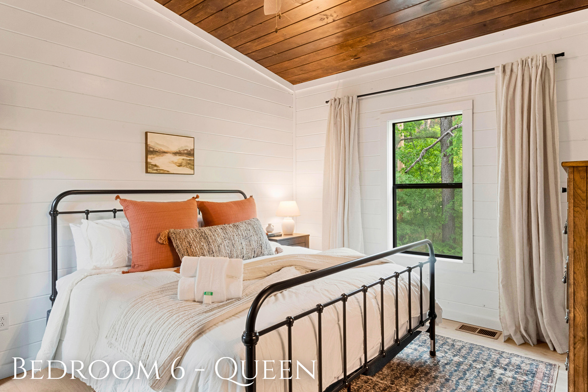 Dream peacefully in this queen bedroom that blends vintage vibes with modern comforts, surrounded by tranquil woodland views.