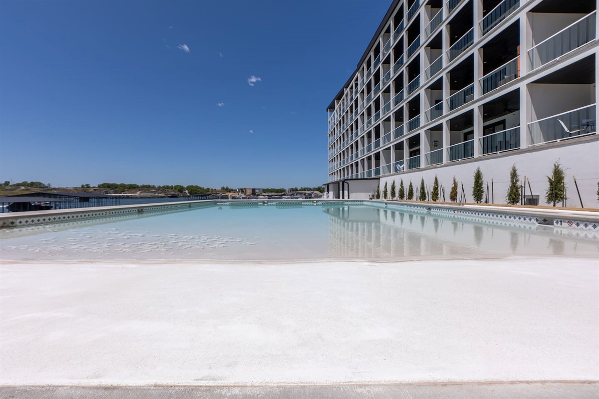 Resort Pool 1 has a beach entry, table in the water, and fountains.