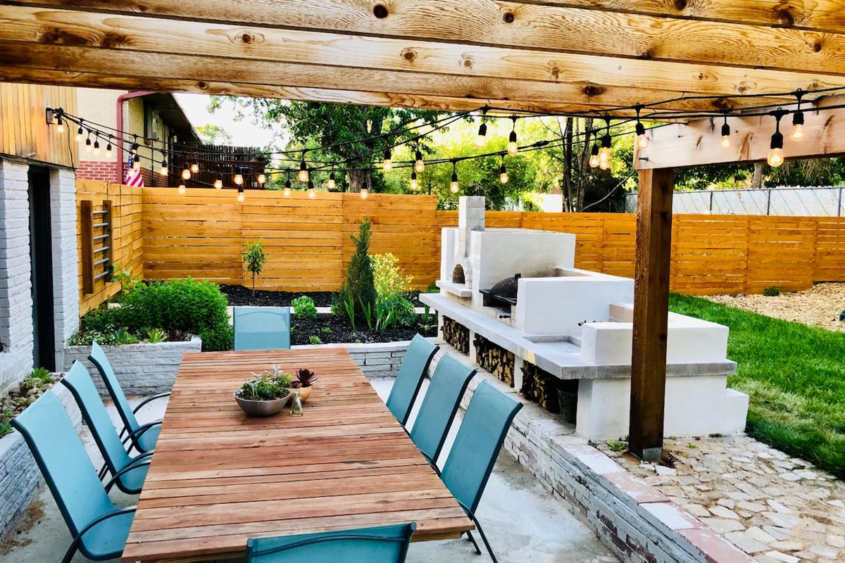 Backyard patio with outdoor kitchen and seating for eight under the twinkle lights