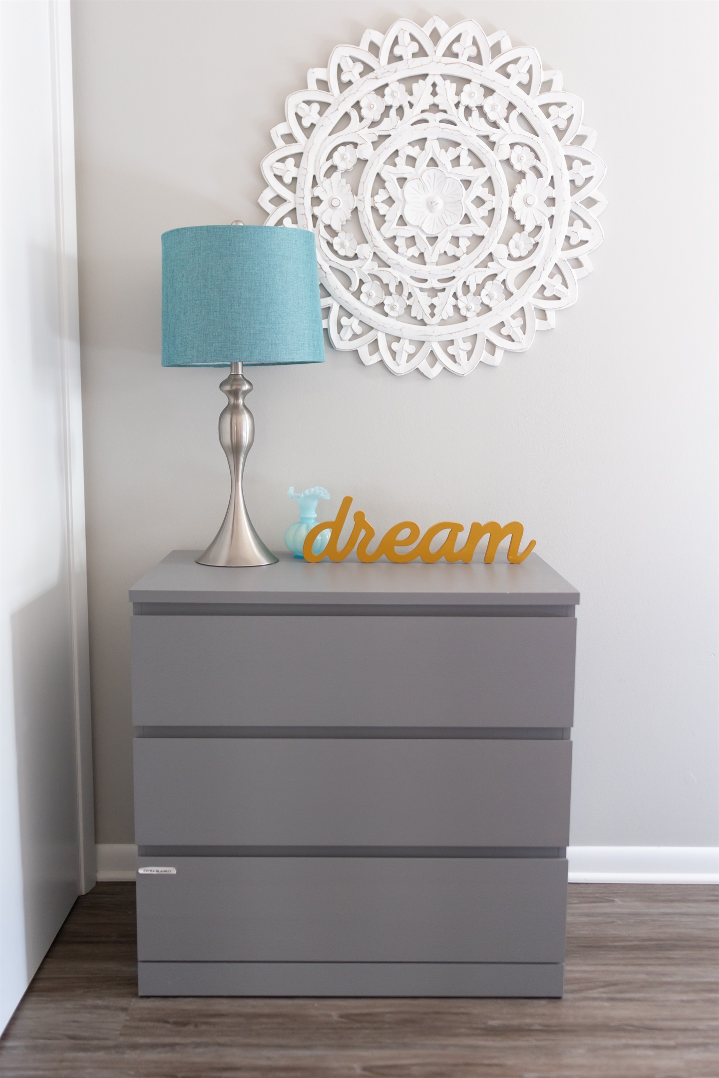 Dresser with extra blankets in bottom drawer.