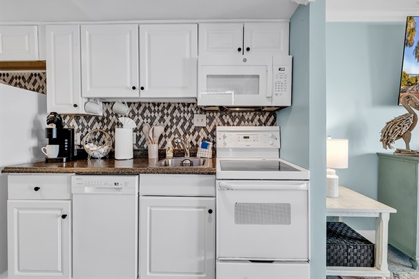 Kitchen with microwave, stovetop, and counter appliances — everything you need to cook at home