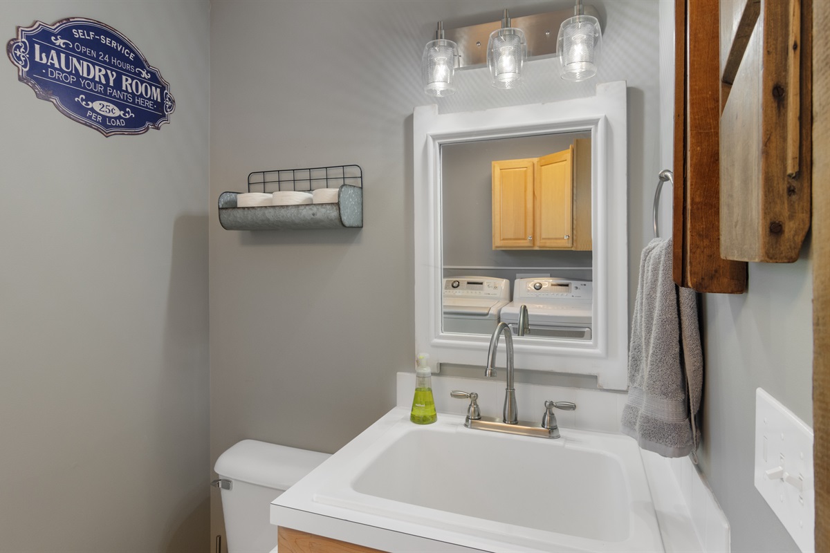 Half bathroom with washer and dryer for guest use.