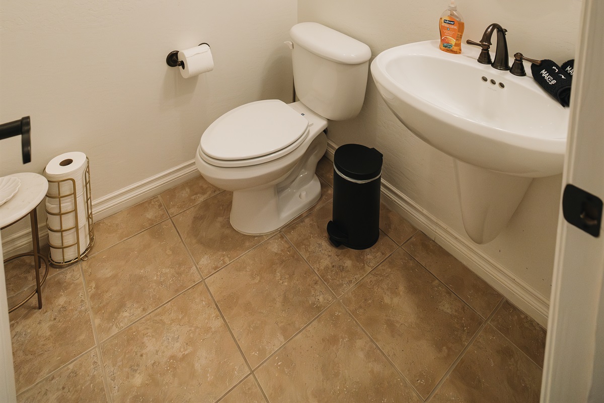 Clean, thoughtfully stocked half bath with warm lighting and elevated finishes—perfect for guests and easy convenience during your stay.