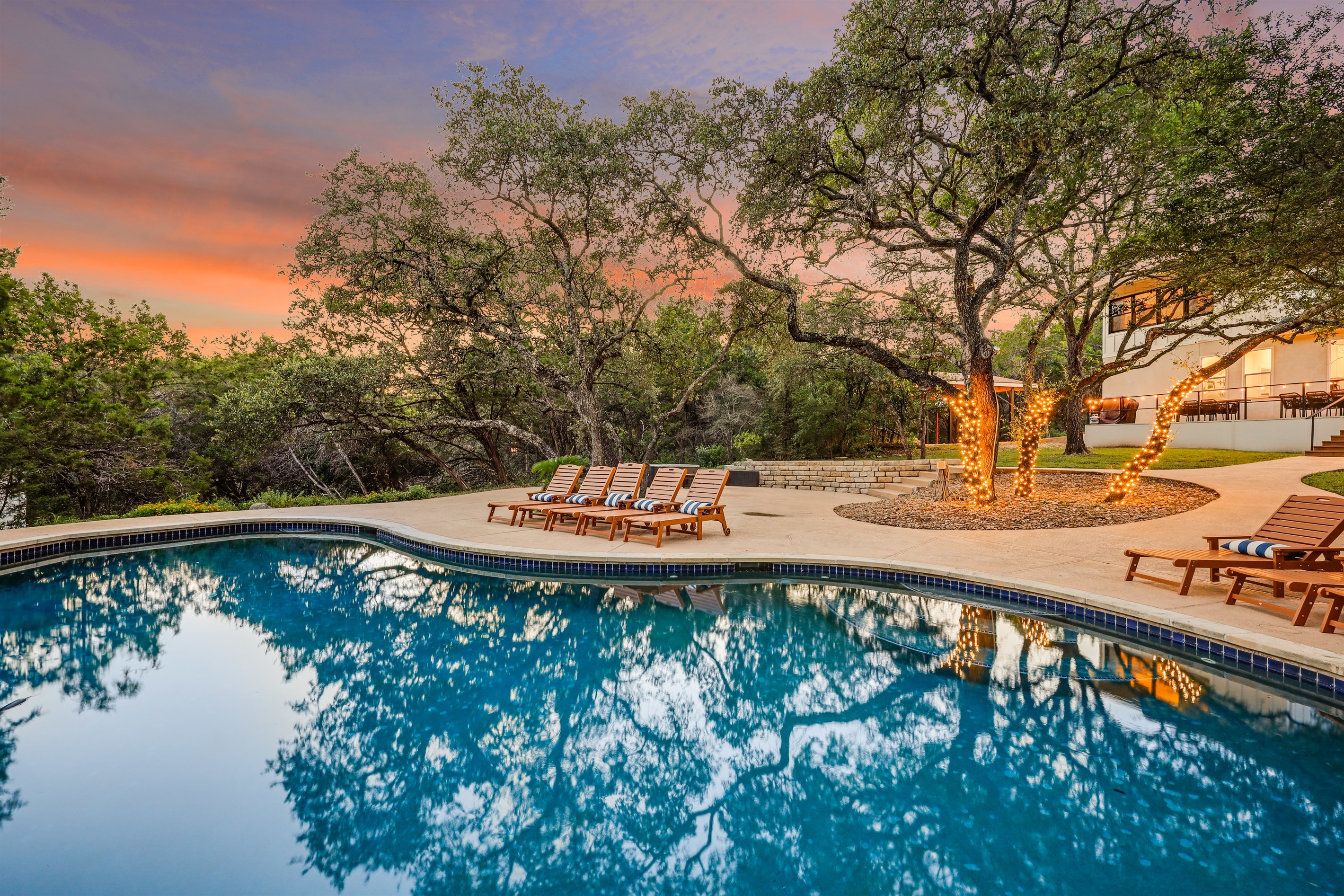 Enjoy the calm of this wooded oasis, where a sparkling pool and soft lighting create a resort-like vibe right in nature’s embrace.