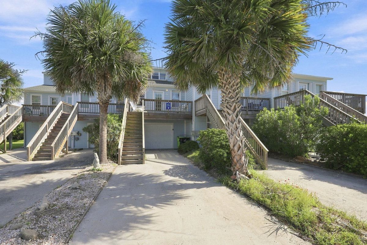 Palm trees sway in the breeze along the scenic drive leading up to your vacation home.