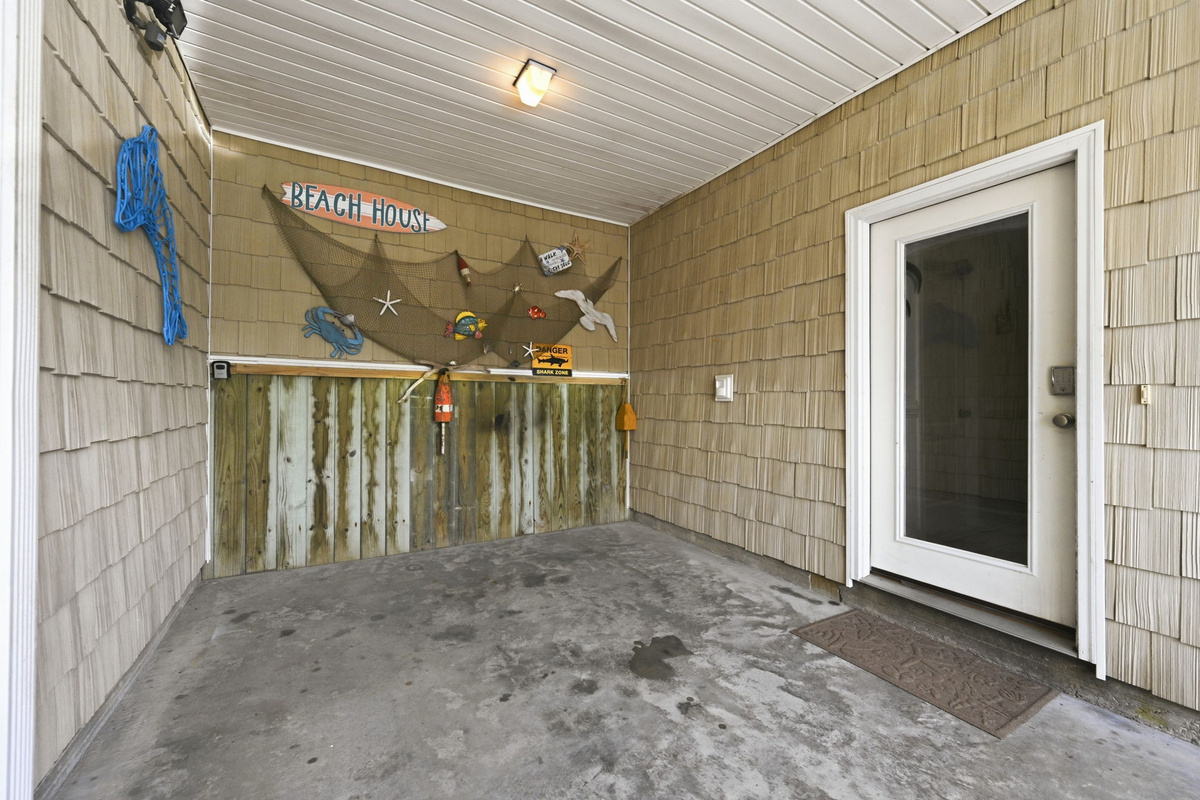 Covered entry patio with beach themed decor and exterior access