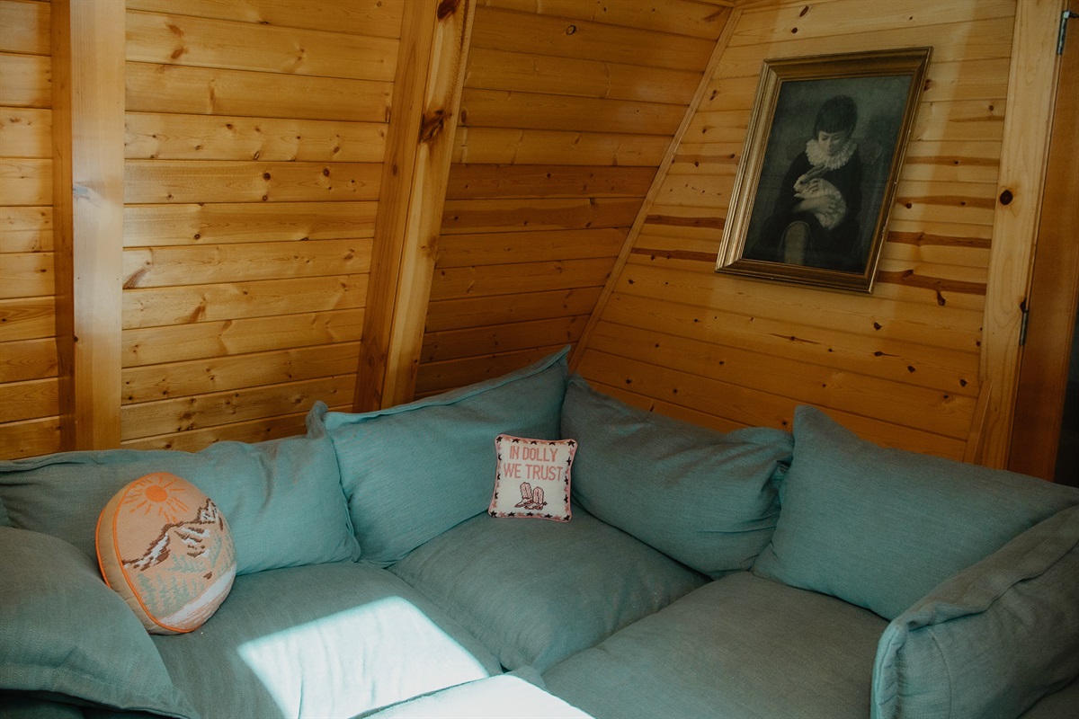 Cozy loft seating tucked beneath vaulted A-frame ceilings creates a perfect spot to lounge, read, or unwind. This thoughtfully designed mountain cabin offers a warm, inviting retreat in Arizona’s White Mountains.