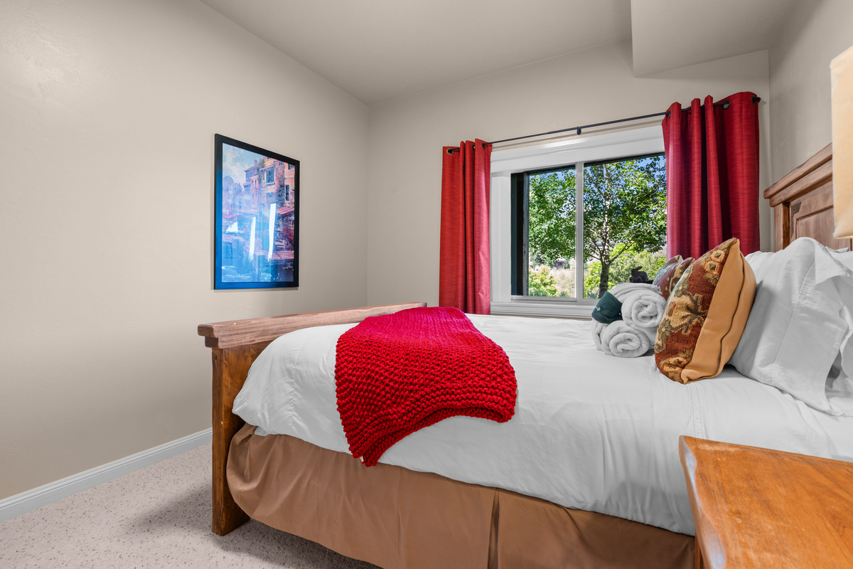 Inviting guest bedroom featuring a queen bed, cozy accents, and natural light — a perfect retreat for a restful night’s sleep.
