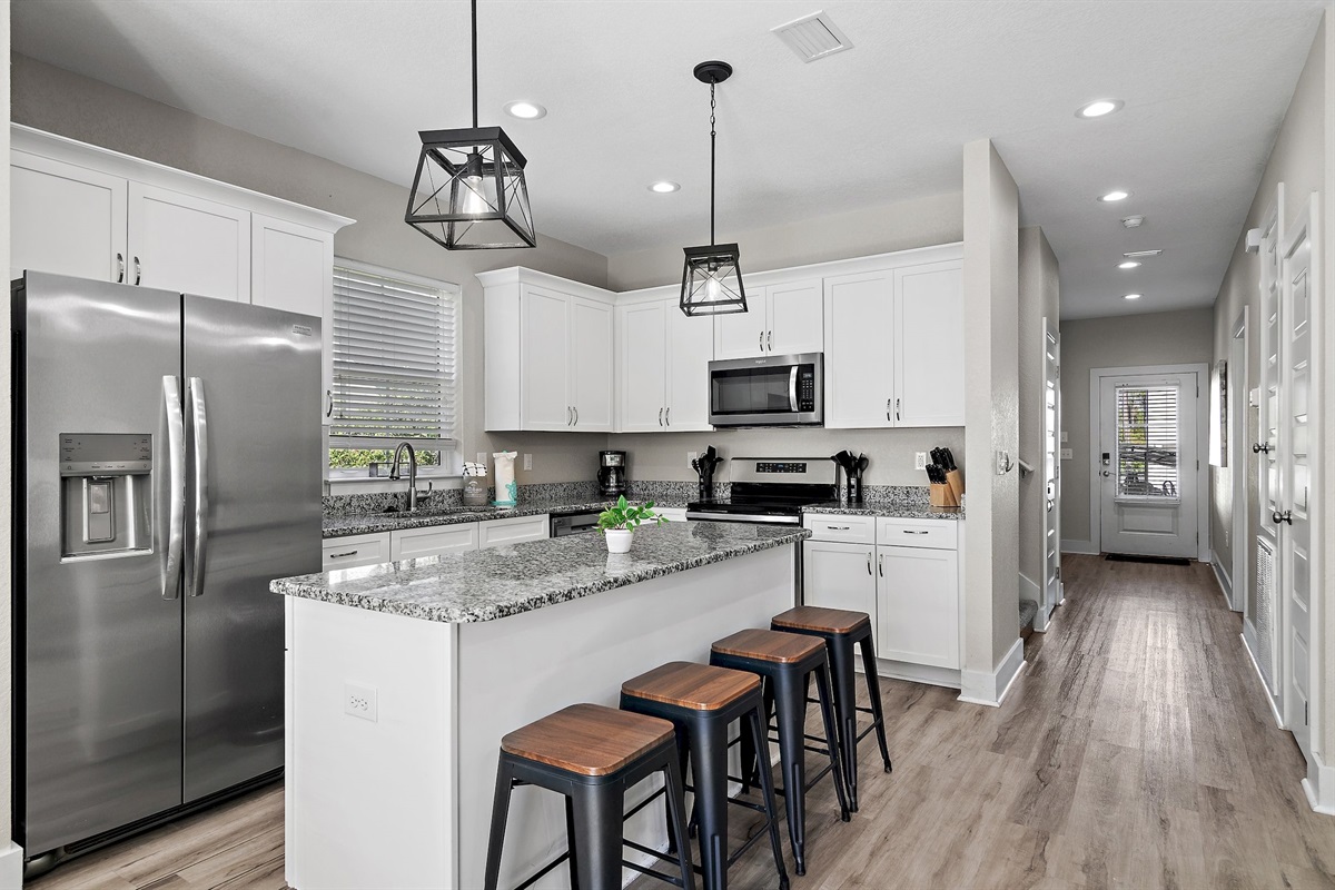 The kitchen is equipped with a large two-door refrigerator with ice maker, stove, oven, coffeemaker and dishwasher.