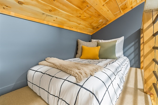 A tucked-away twin bed in the loft, ideal for a cozy night&rsquo;s rest in a peaceful setting.