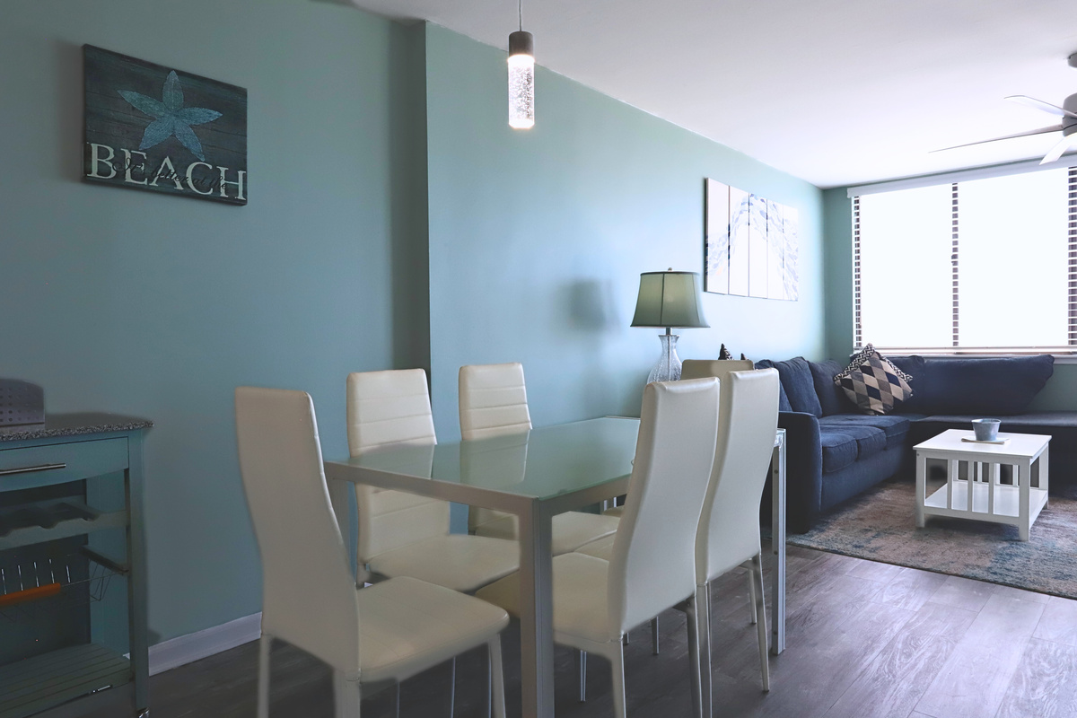 An elegant dining area featuring a sleek white table and chairs, exuding sophistication and charm—perfect for hosting meals and creating memorable moments.