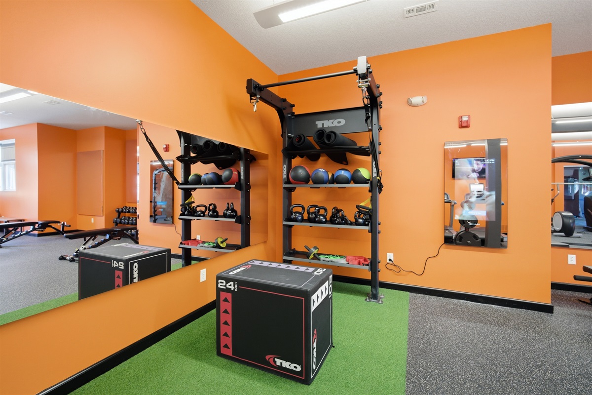 Functional training area with turf flooring, sled equipment, plyometric boxes, and open space for HIIT, stretching, or mobility work.