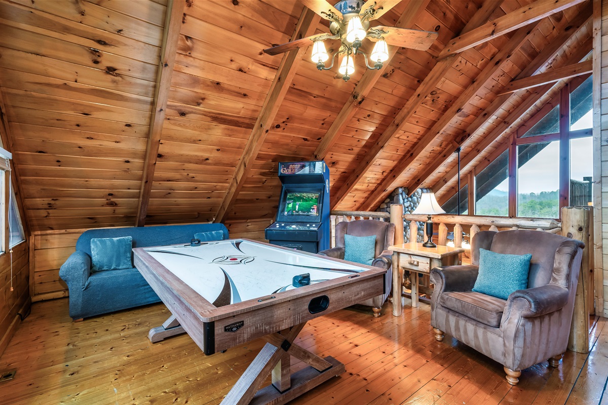 Cozy loft area, best for relaxing, with two queen beds (left) air hockey, golden tee arcade and queen sleeper sofa