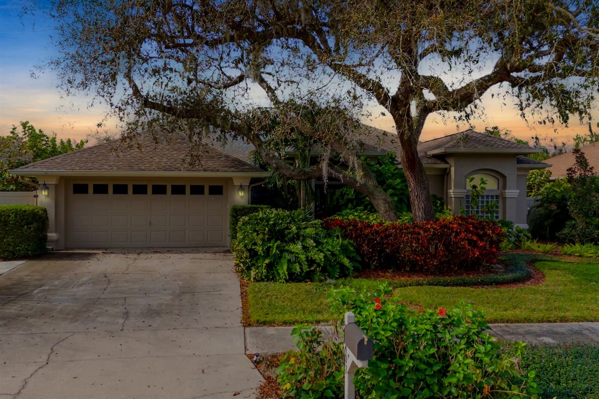 Welcoming front entry shaded by mature trees.