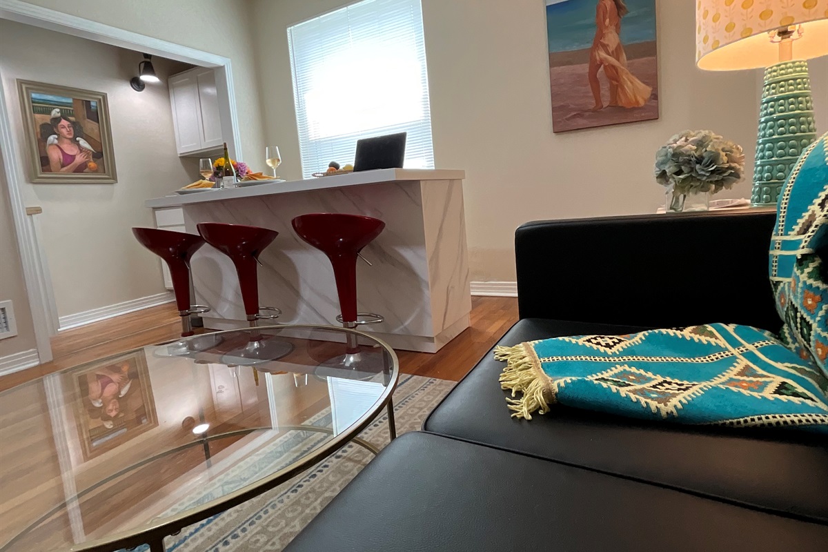 Living area features comfy couch, 2 side chairs, and seating at the island.