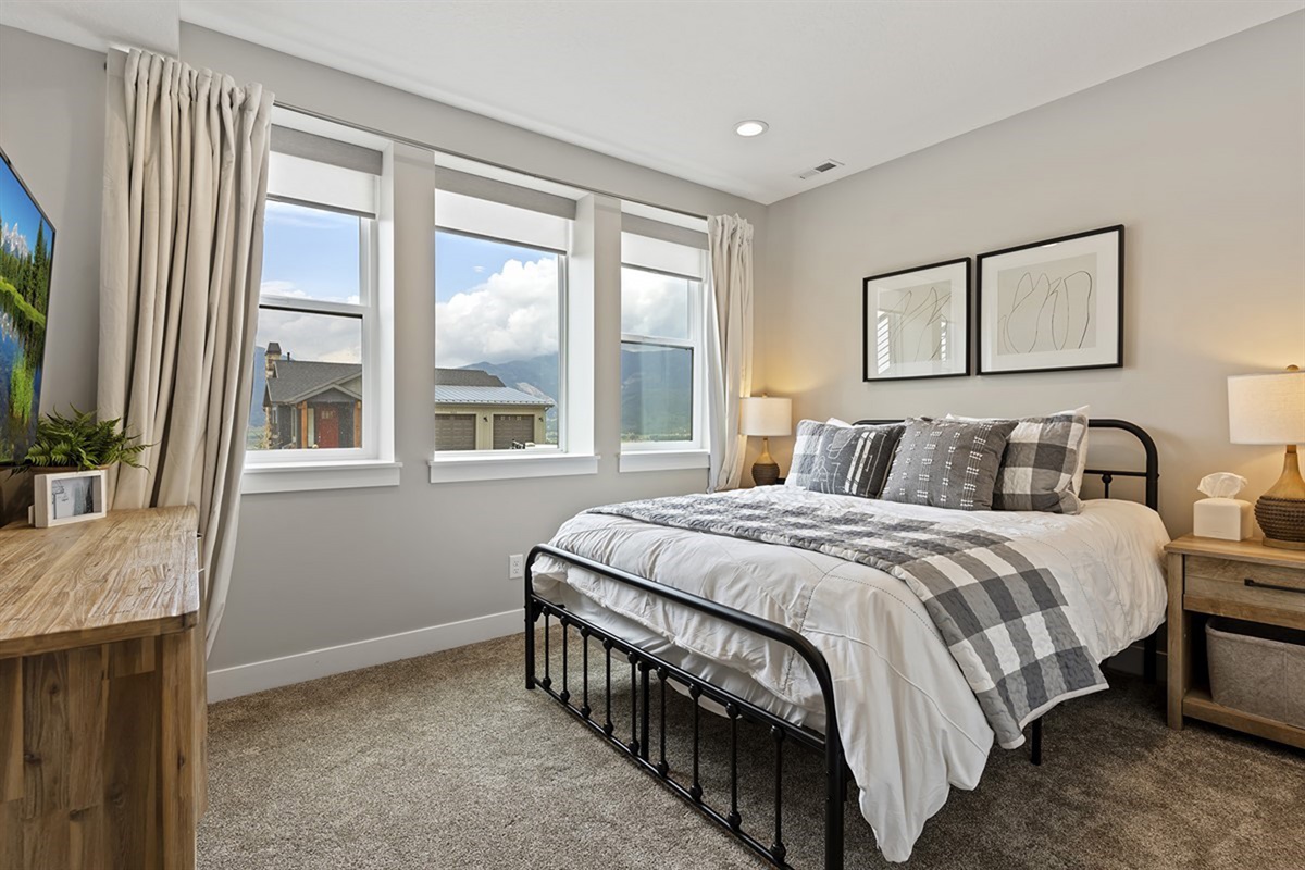 Bright and inviting bedroom with king bed, plush bedding, and natural light.