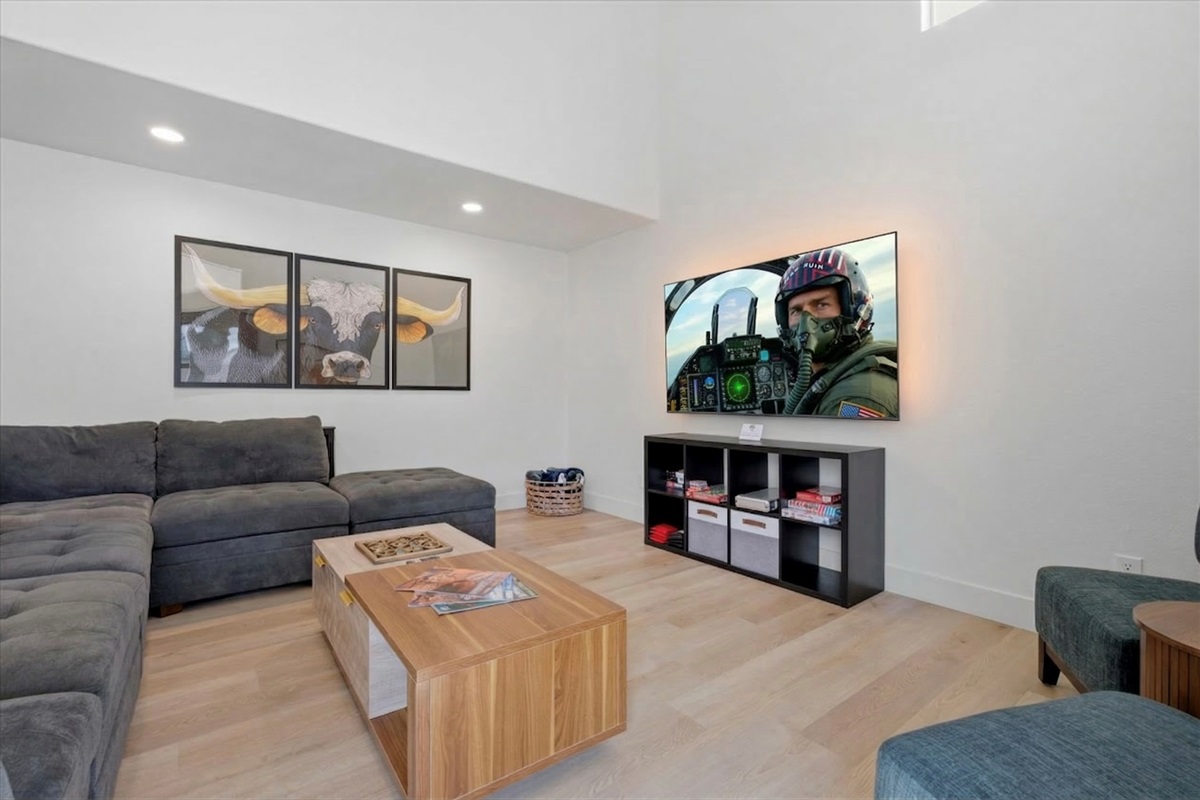 Large living room has an extra large sectional, individual chairs, big screen smart TV, board games, two different areas to charge your devices.