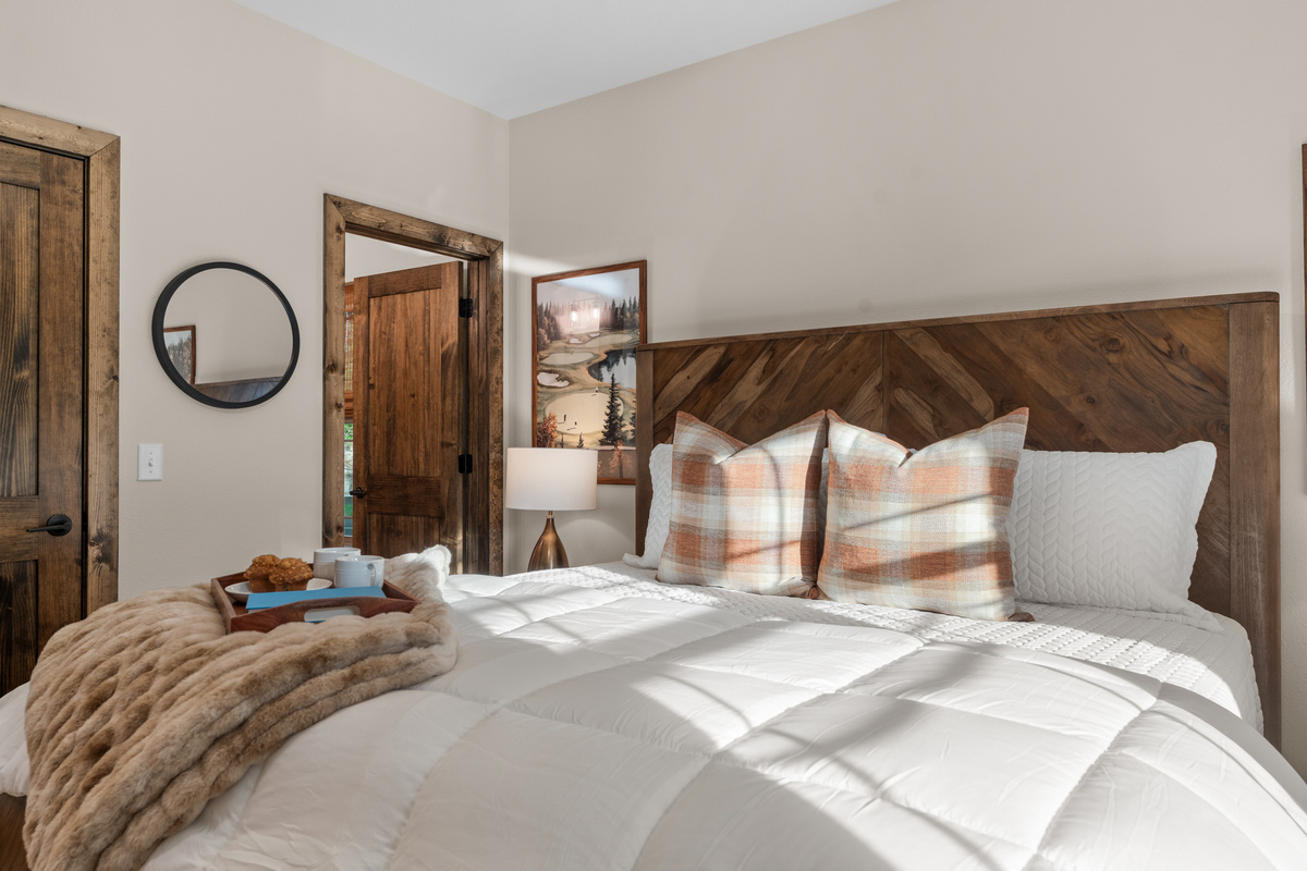 This main level king suite pairs a walnut chevron headboard with framed fairway art and mirror to help soak the room with natural light.