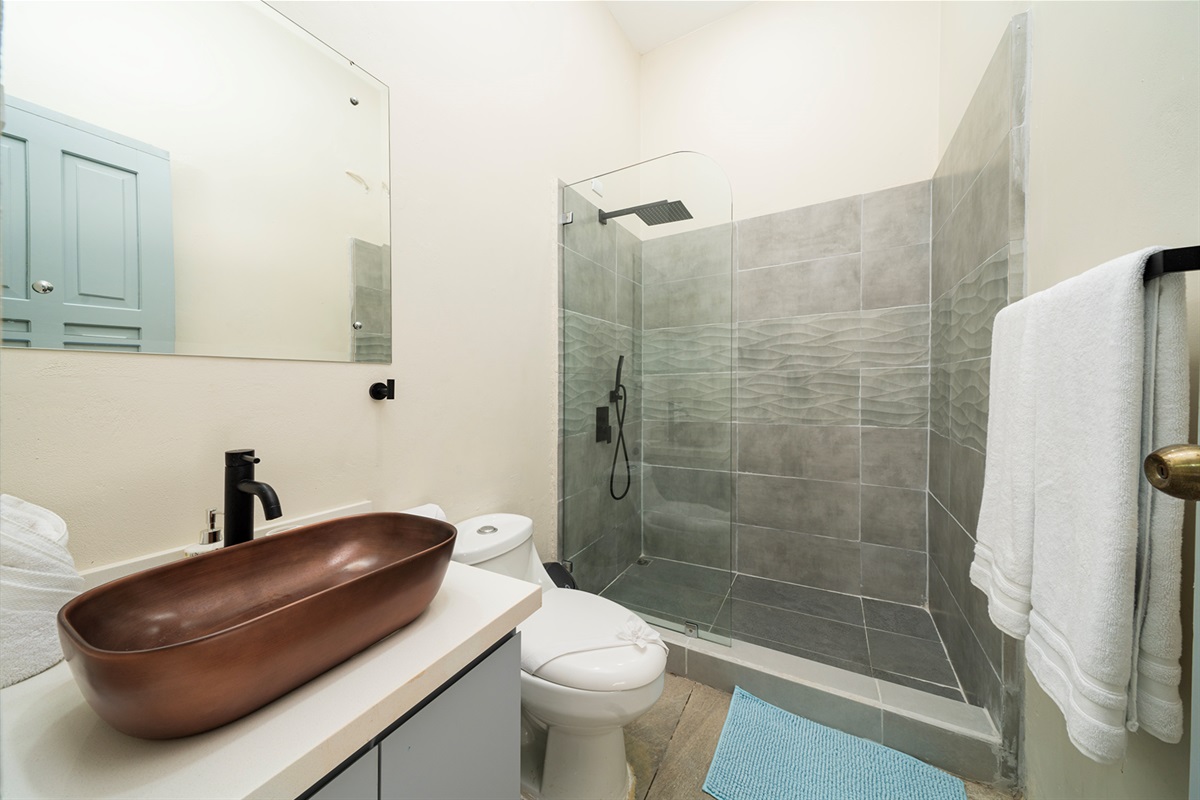 The ensuite bathroom has a walk in shower and copper sink