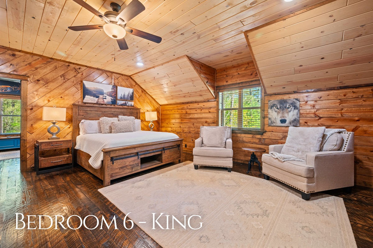 This generously sized bedroom offers a relaxing setting with comfortable seating and warm lighting, creating a peaceful place to unwind and recharge.