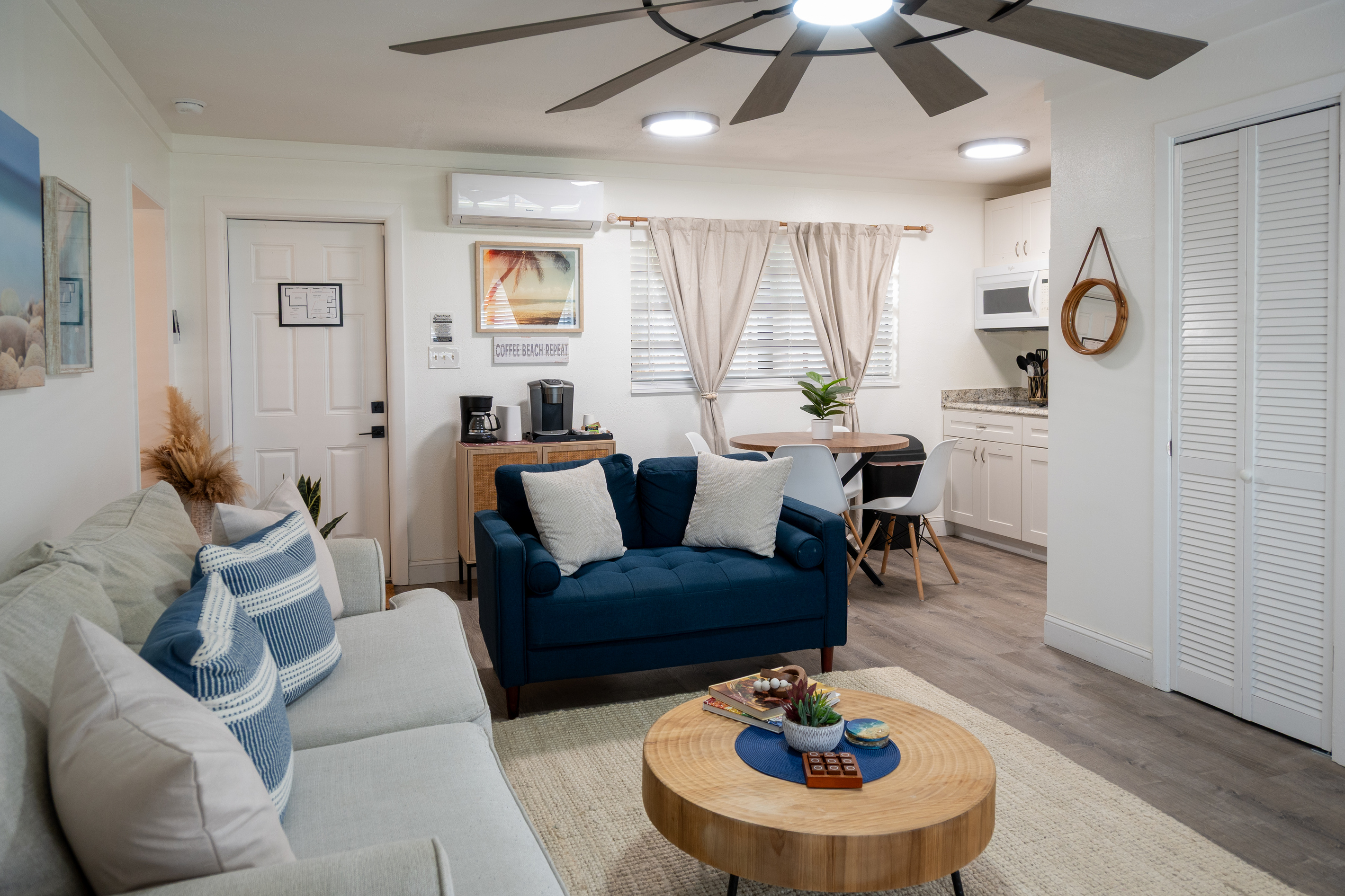 Bright open living room with sleeper sofa, full kitchen and dining nook – minutes from the beach