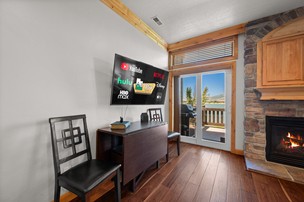Comfortable gathering space featuring a fireplace, Smart TV, and stunning lake scenery.