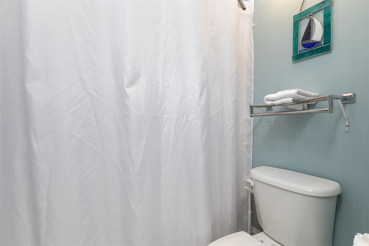 Airy, coastal-style bathroom with a walk-in shower and fresh towels provided for your stay