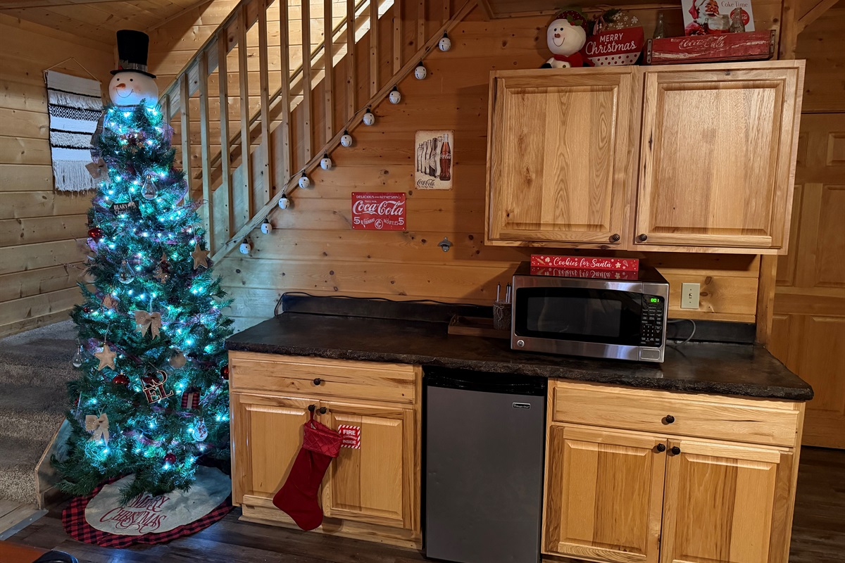 Game-room kitchenette by the tree with mini-fridge & microwave—perfect for late-night snacks.