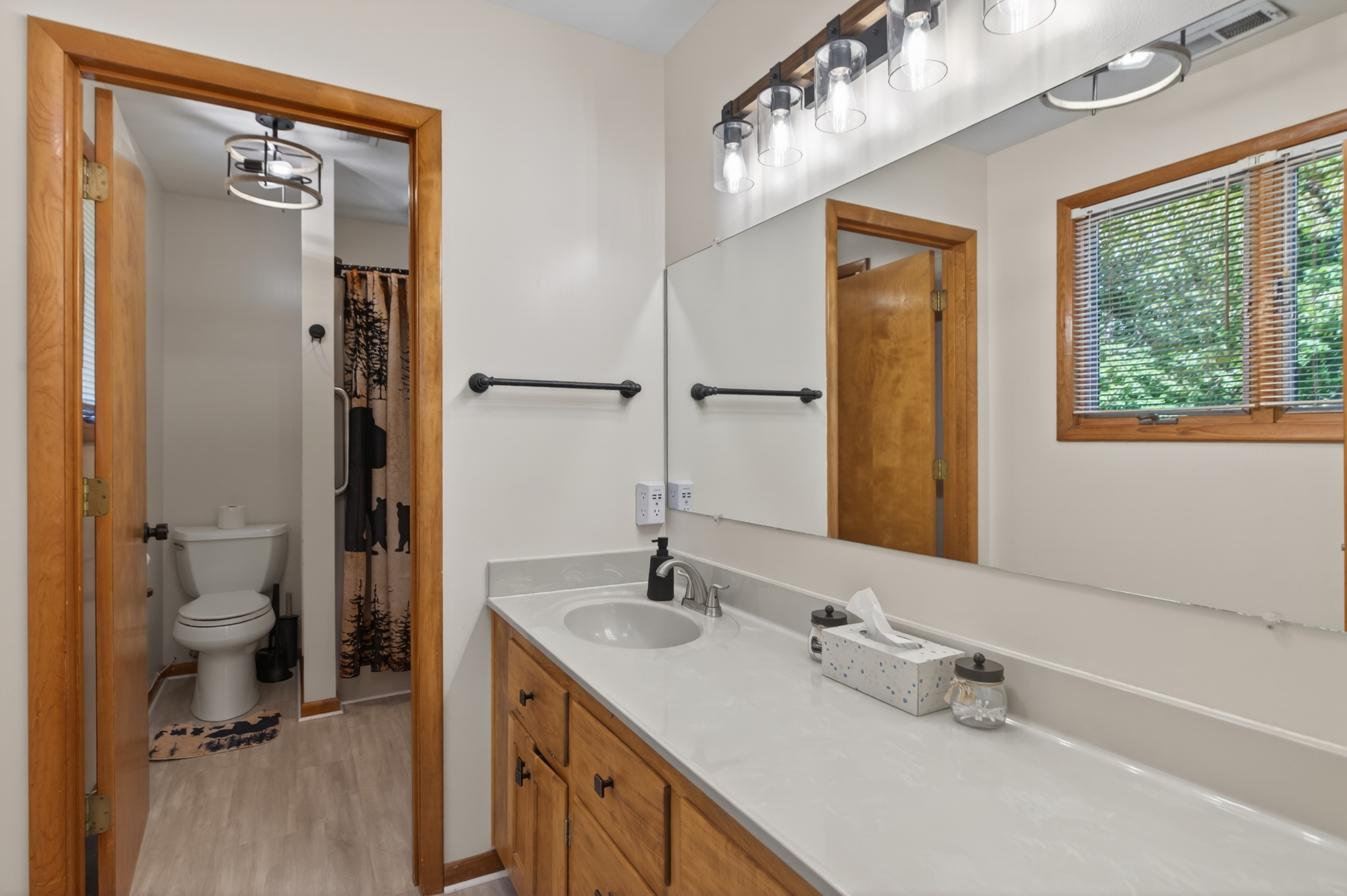 Bright and Inviting Bathroom: Refresh in this stylish space with modern lighting and nature views!
