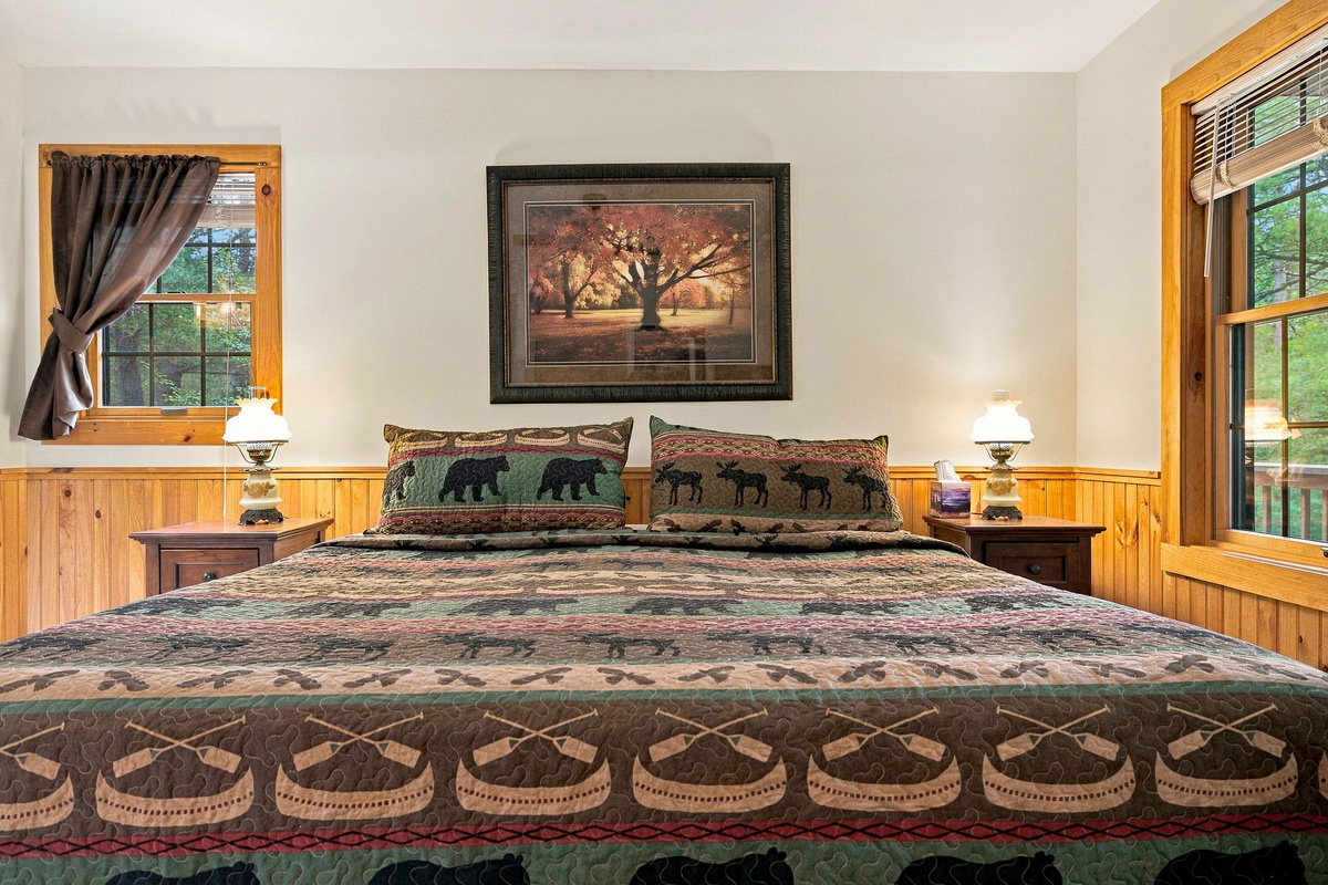 Spacious primary bedroom with a king bed and warm Adirondack-inspired décor.