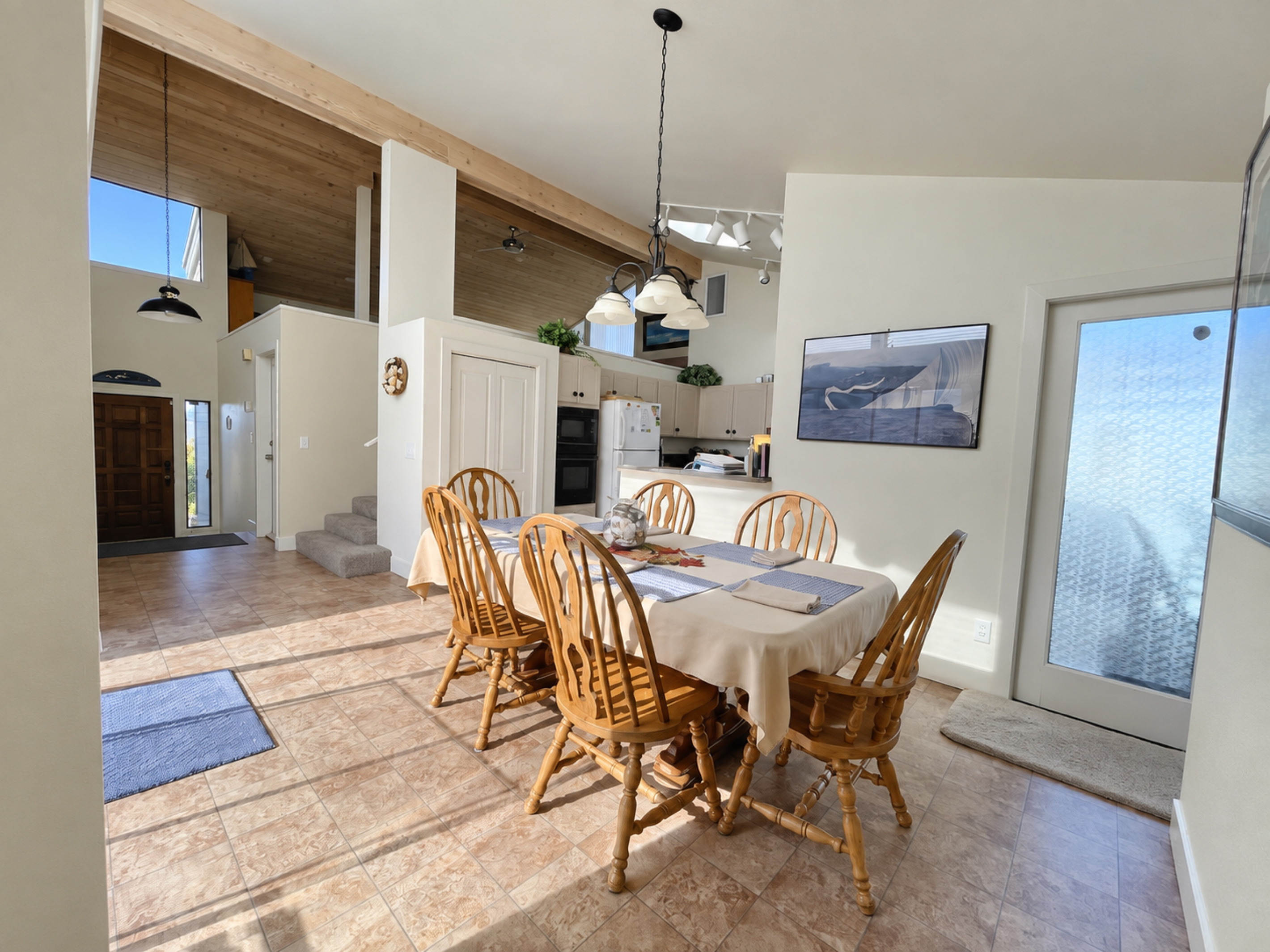 View from dining area looking up towards Living room. Vaulted Ceilings, open floorpan and numerous windows/skylights give home an open feel with lots of natural lighting.