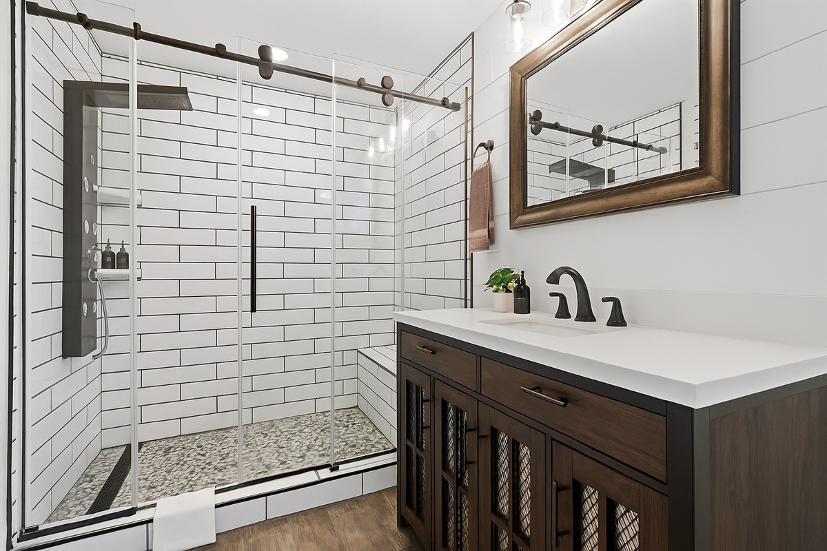 Spacious walk-in shower with subway tile and sliding glass doors—designed for comfort and style.