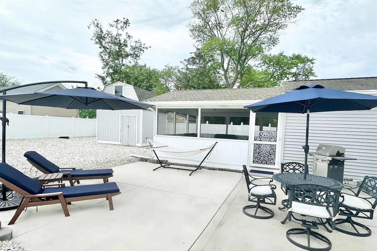Make the most of the sunshine on our spacious concrete patio. This versatile outdoor space features comfortable navy lounge chairs, large umbrellas, a relaxing hammock, and a dining set with a grill—perfect for hosting summer BBQs and fresh air.