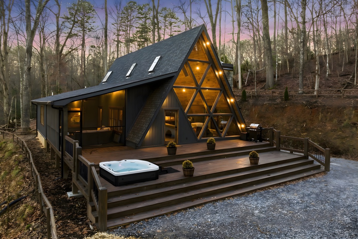 Unwind beneath towering trees in this one-of-a-kind A-frame, featuring expansive decks, glowing interiors, and total tranquility.