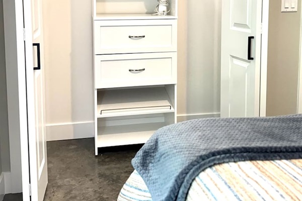 Lighted closet with a closet organizer has plenty of space for your hanging items, hangers, extra pillows, and blankets, as well as a steam iron for your clothes.