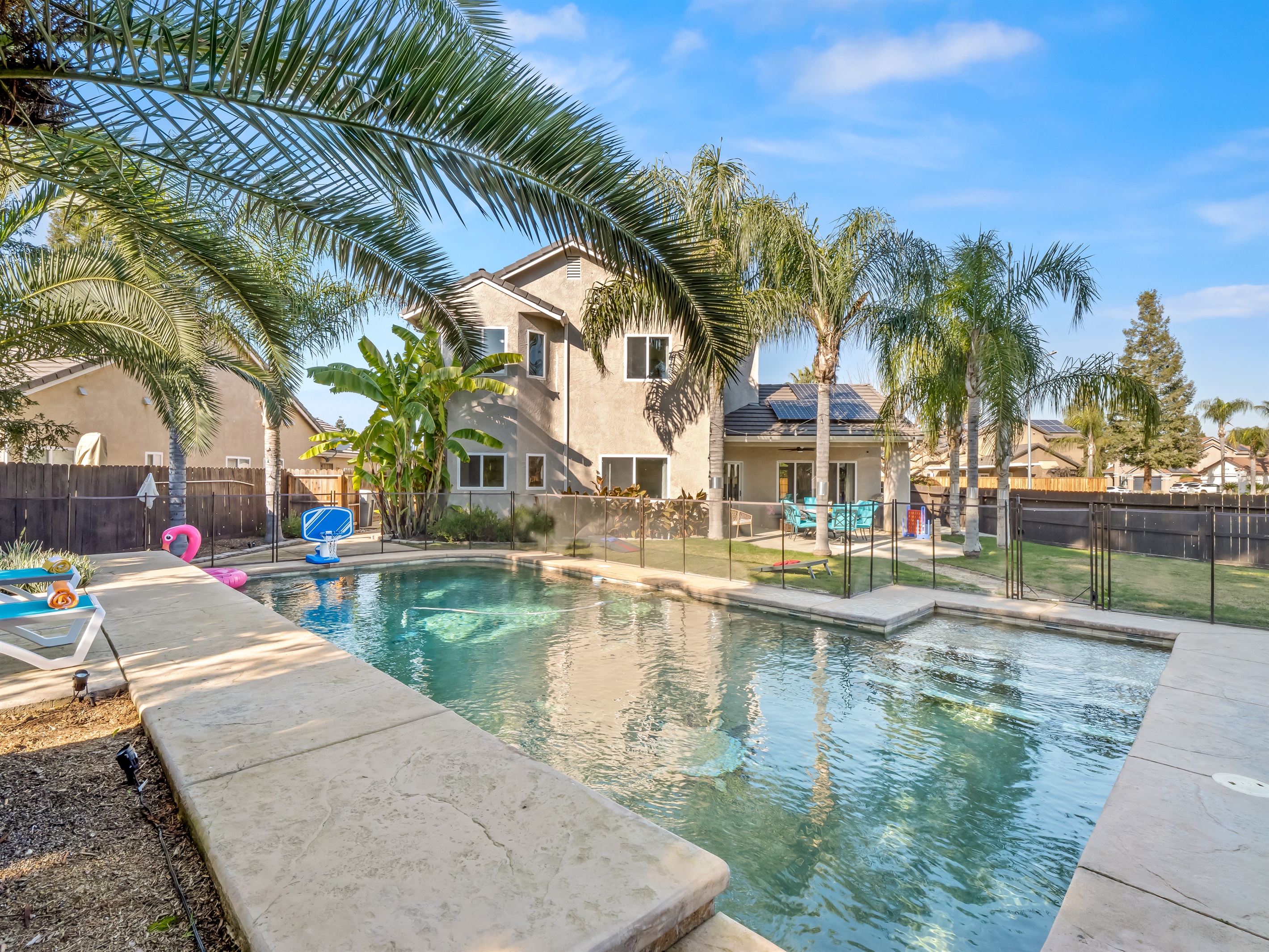 Clean pool lines, raised edge, and layered landscaping elevate the backyard into a high-end retreat experience.