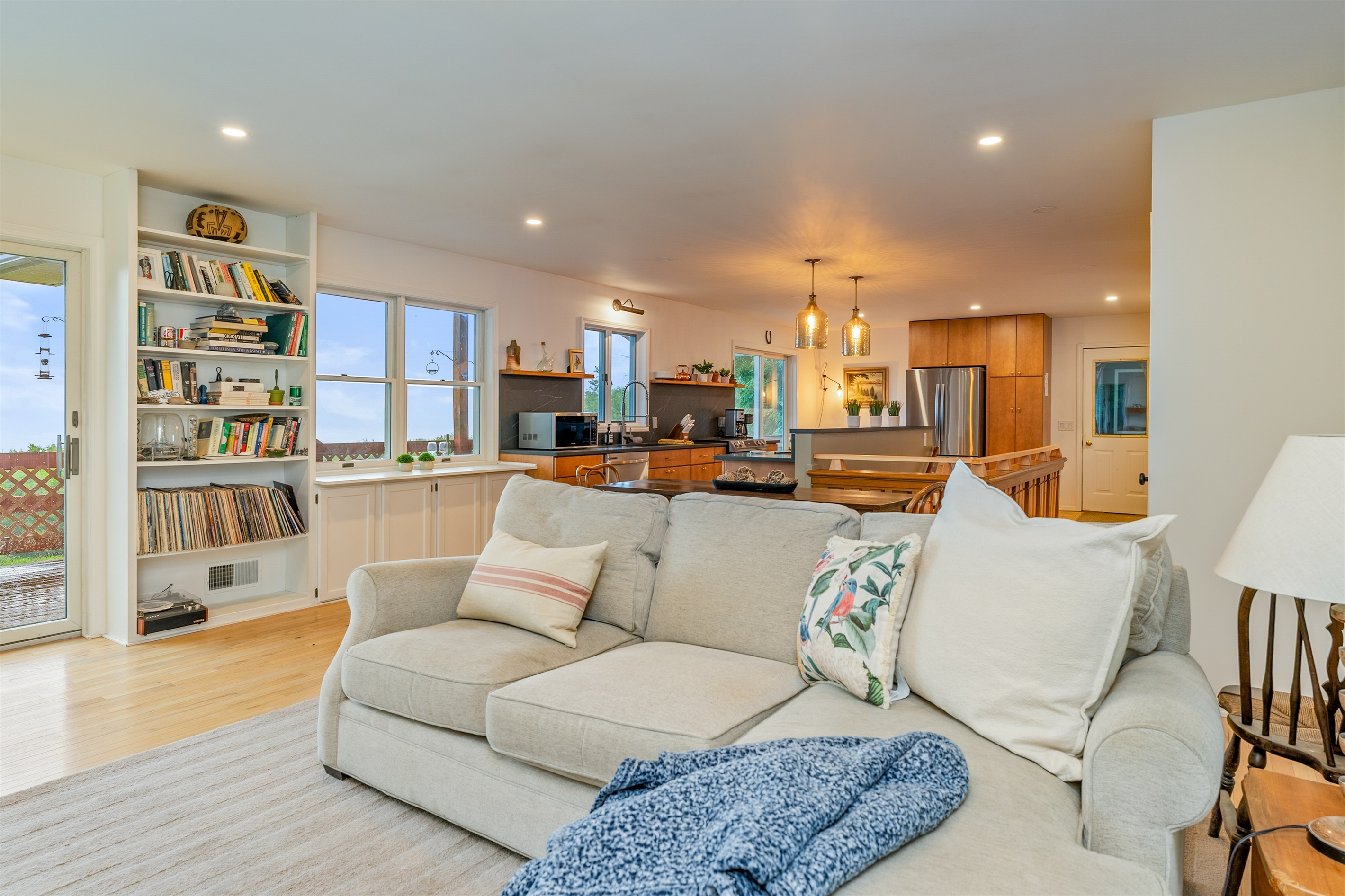 This bright and airy living room offers cozy seating and seamless flow into the kitchen, ideal for entertaining or relaxing