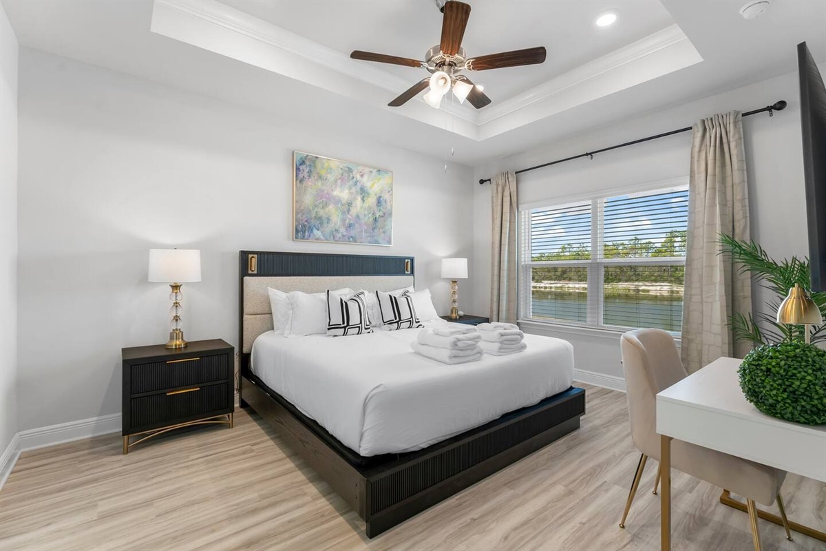 Enjoy comfort and style with a bright bedroom, cozy lamps, and a ceiling fan.