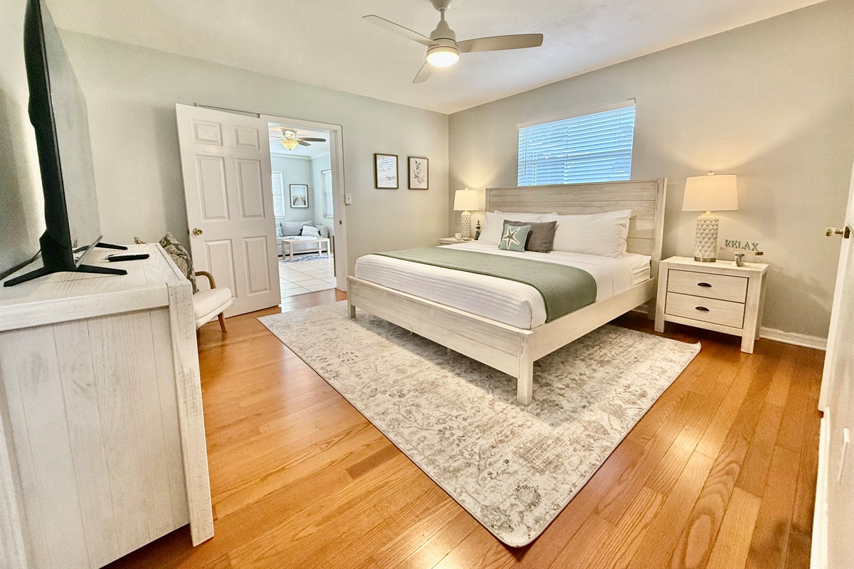 Retreat to the master bedroom, where a plush king mattress, modern ceiling fan, and calming decor invite pure relaxation.