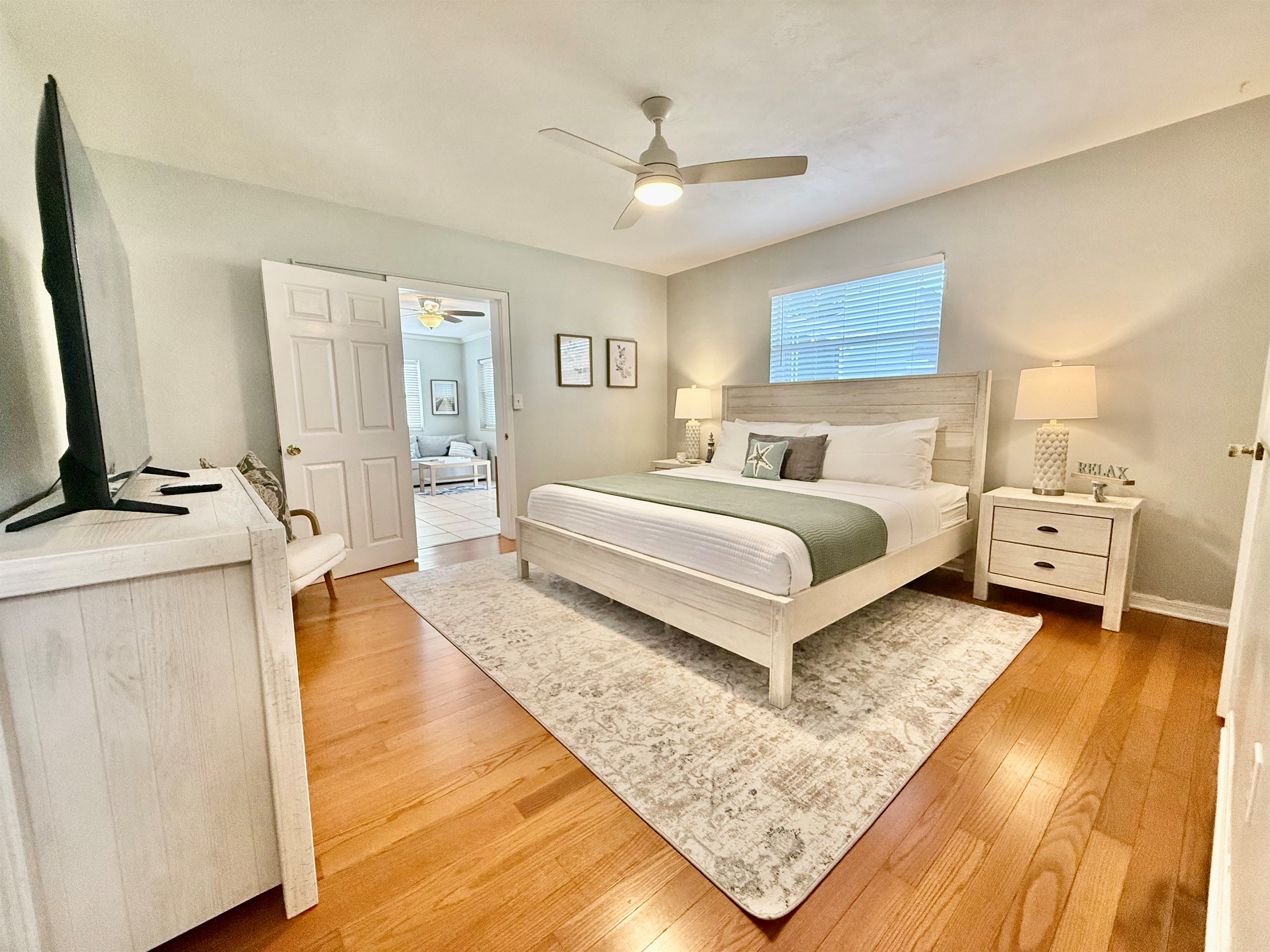 Retreat to the master bedroom, where a plush king mattress, modern ceiling fan, and calming decor invite pure relaxation.