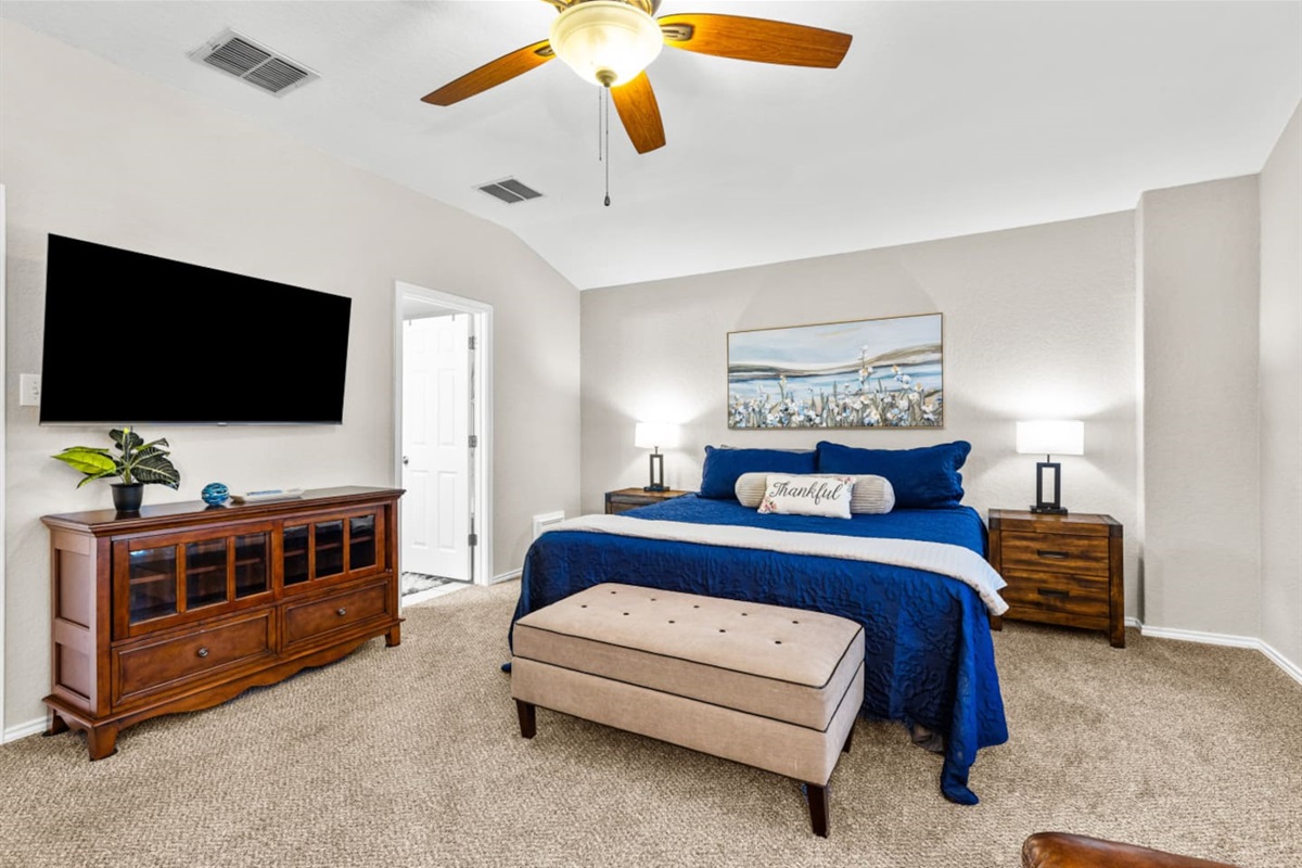 Spacious primary suite with king bed, reading nook, room-darkening shades, premium linens, and a Smart TV with streaming—your private retreat after a full day in San Antonio.