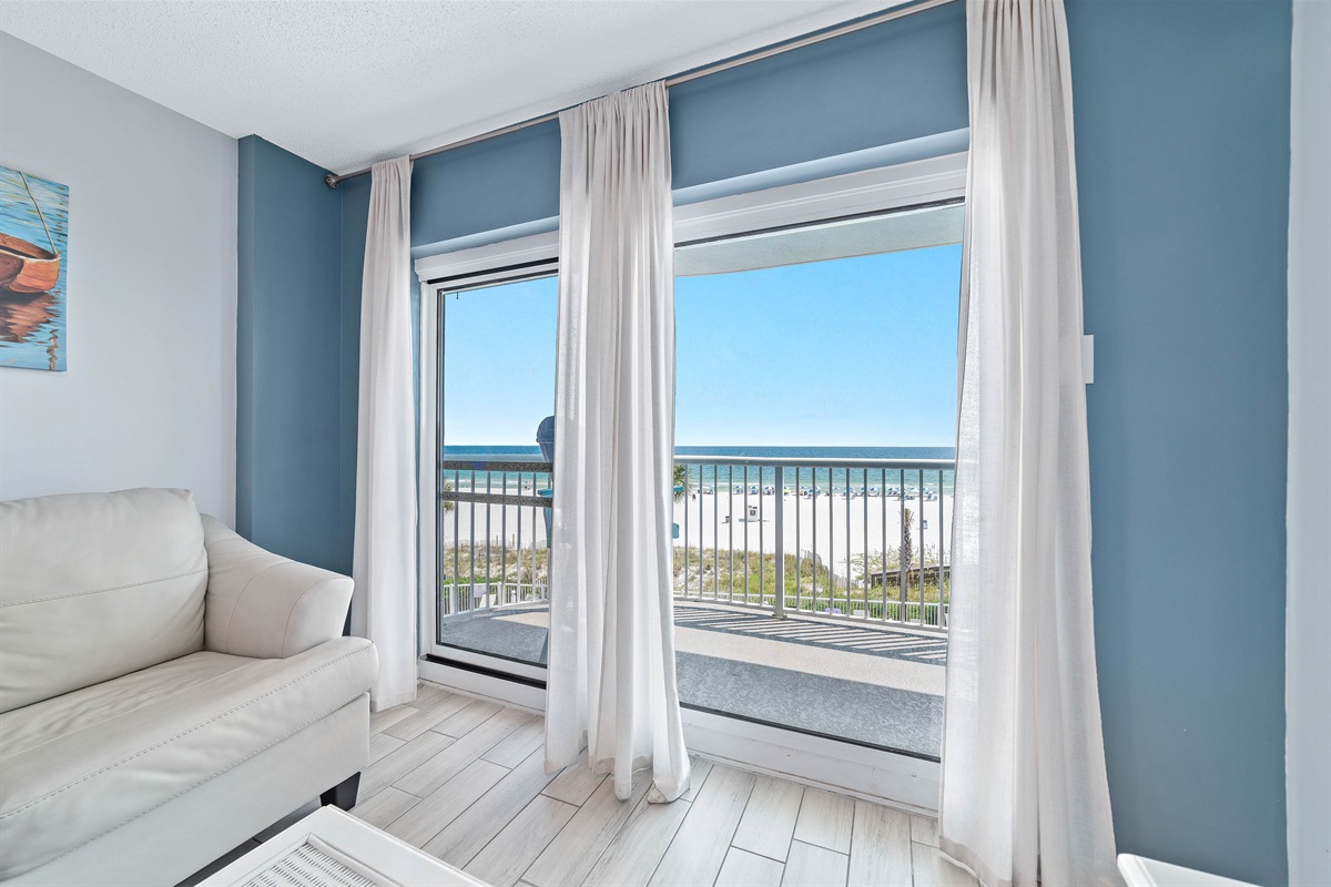 Experience the beauty of indoor-outdoor living with expansive sliding doors leading to a private balcony overlooking the ocean.